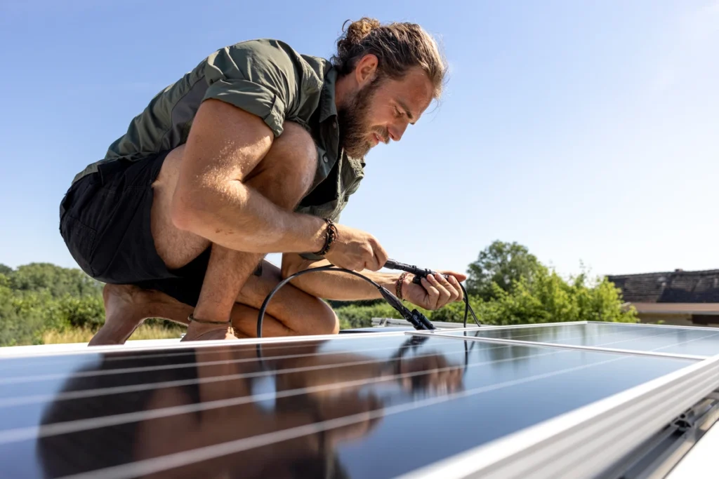 man installing solar panels on roof