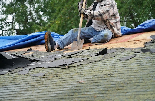 how-often-technician-sitting-on-a-roof-removing-shingles-with-a-shovel