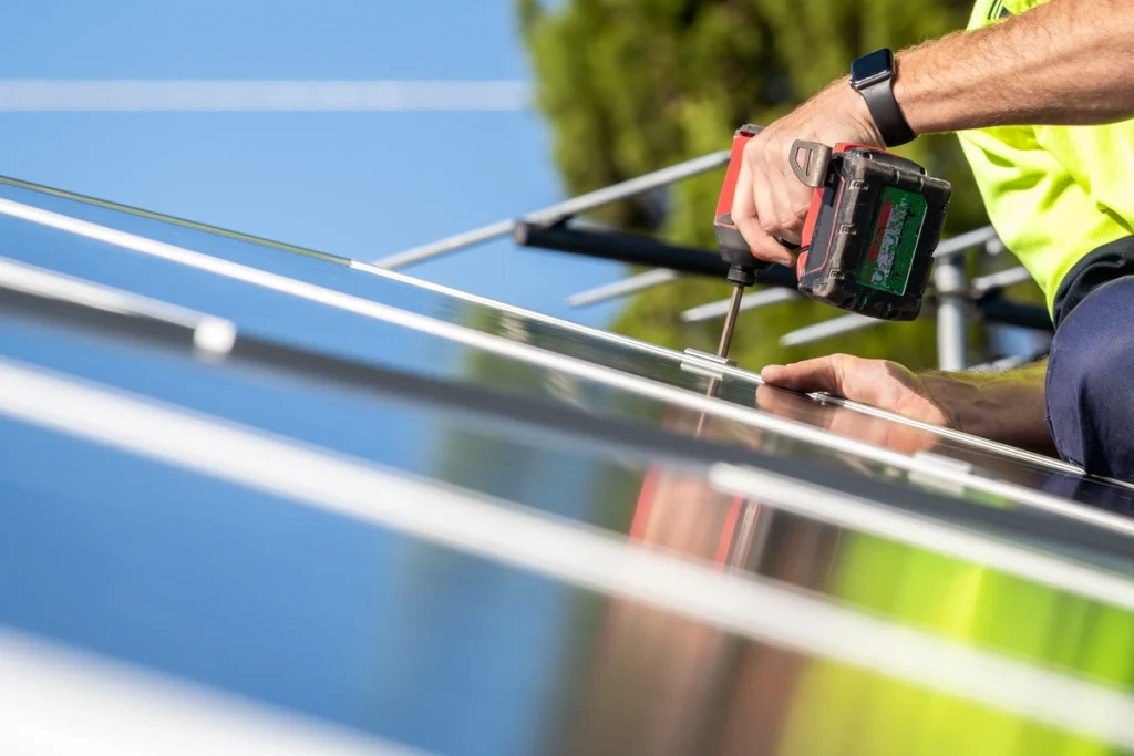 roof warranty-close up image of a roof repair tech using power tools on a sloped roof