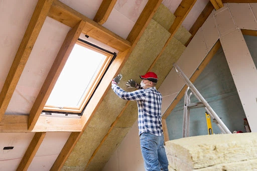 roof insulation-technician applying insulation to interior walls of roof