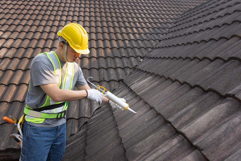 roof sealant-roof tech applying sealant to tile roofing materials