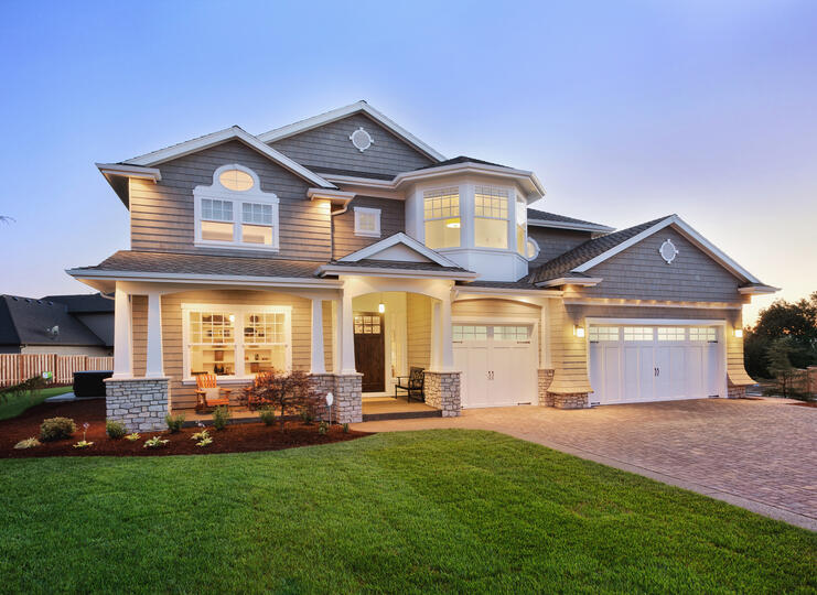 roofing clermont-gray sided house with dark gray shingled roof and ambient lighting