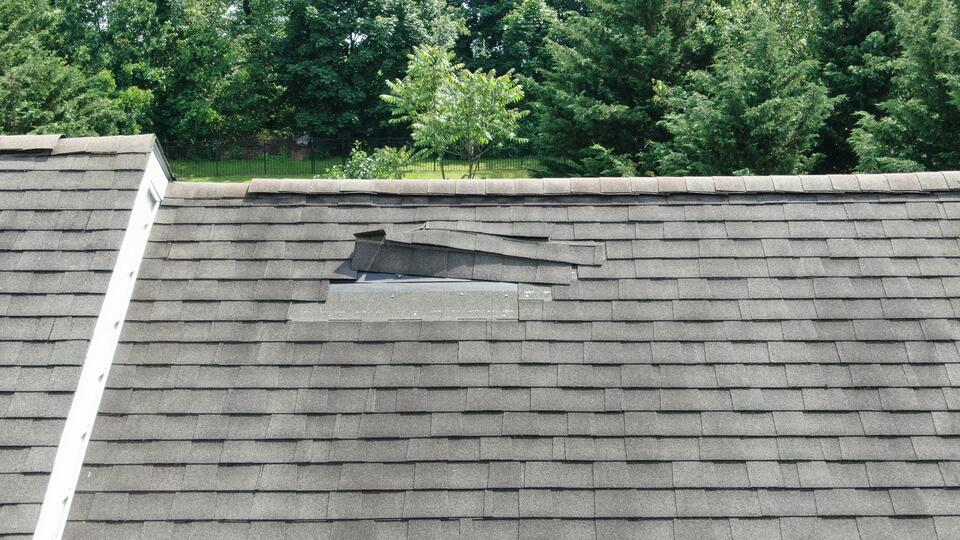 storm damage roof inspection-wind damage to shingled roof