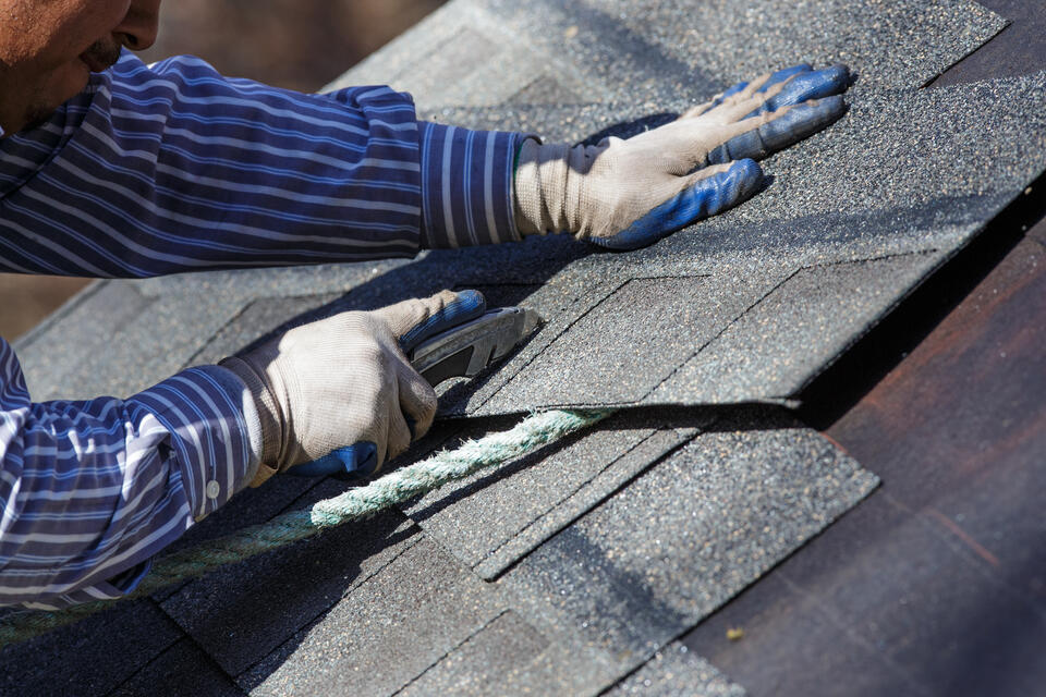 best roof shingles-man installing new shingles on a house roof