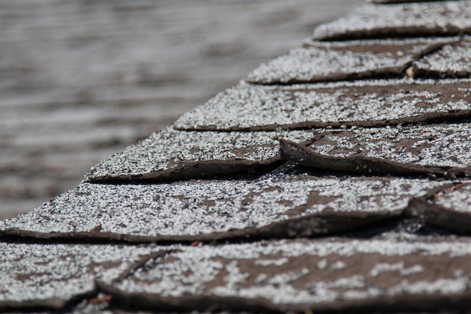 curling shingles-micro close up of roof shingles curling at the edge