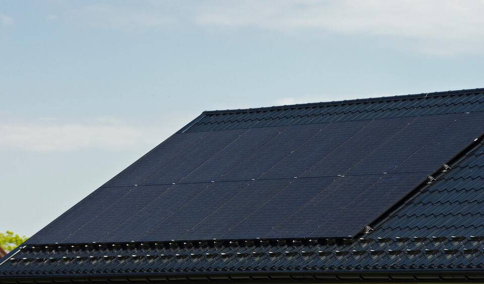 solar panels on metal roof-black metal shingle roof with large black solar panels installed on the surface