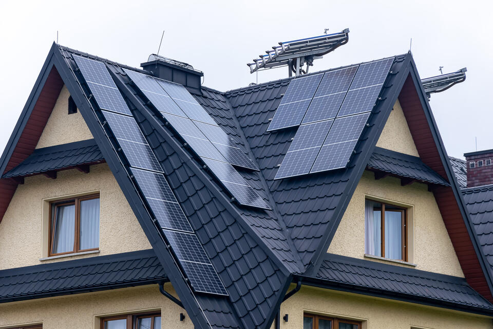 solar panels on metal roof-black metal shingle roof with several solar panels installed on the surface